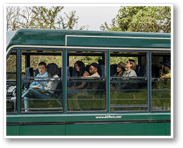 A man and a woman are sitting on a bus, engaged in conversation. The woman is wearing sunglasses. AI generated content