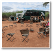 A group of chairs are arranged in a circle in a dirt area. AI generated content