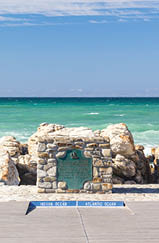 The survey marker and ikon of Cape Agulhas (also known as Cape of the Needles) - the southern-most tip of Africa, rocky coastline where Atlantic and Indian Oceans meet
