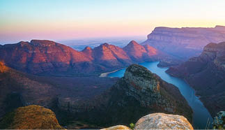 view of three rondavels and the blyde river canyon at sunset in south africa