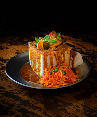 A Durban Bunny Chow - or a quarter mutton bunny - served with sambals. This is an iconic Durban meal consisting of a section of a loaf of bread hollowed out and filled with mutton curry and gravy. 