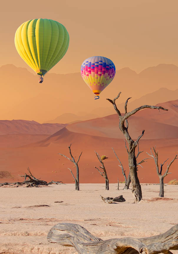 Hot air balloon flying over Dead trees in Dead Vlei - Sossusvlei, Namib desert, Namibia