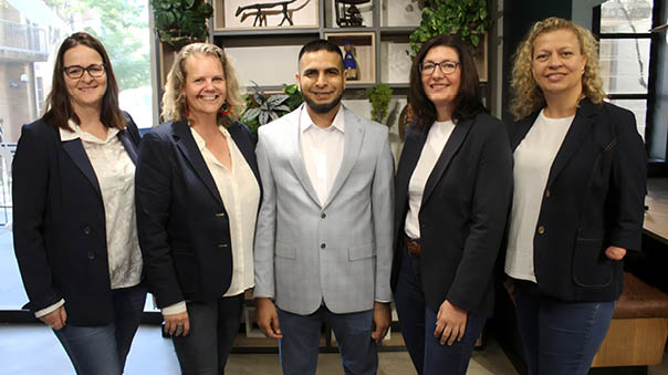 Five women and one man pose for a picture. Description generated by AI