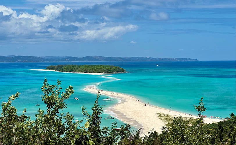 A beautiful beach with a clear blue ocean and a sandy shore. Description generated by AI