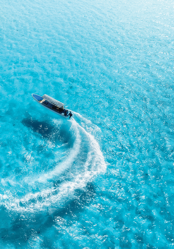 A boat is in the water, leaving a trail of water behind it. Description generated by AI