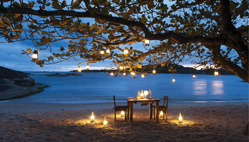 A candlelit dinner on the beach. Description generated by AI