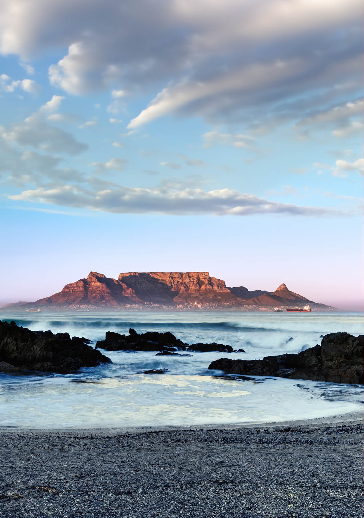The mid winter sunrise lights up the front of Table Mountain as viewed from Blouberg in Cape Town, South Africa.