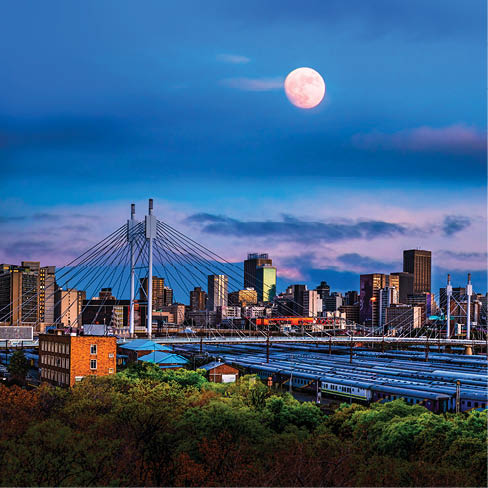 Long exposure shot of Johannesburg city skyline and Nelson Mandela bridge with moon in the sky