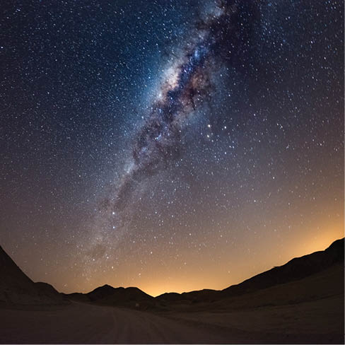 Starry sky and Milky Way arc, with details of its colorful core, outstandingly bright, captured from the Namib desert in Namibia, Africa. The Small Magellanic Cloud on the left hand side.
