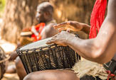 A closeup shot of two African men playing a musical instrument next to each other