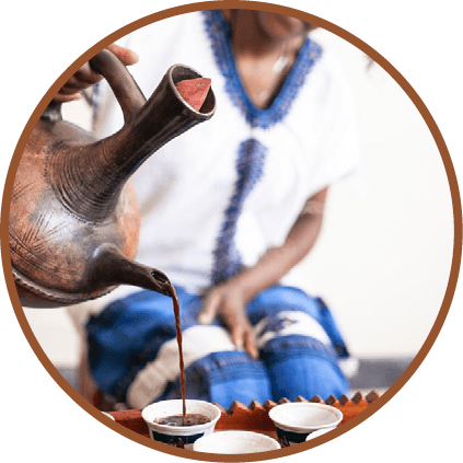 Closeup of womans hand as she serves coffee from a traditional pot in Ethiopia.