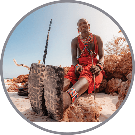 A man wearing red pants is sitting on a rock. Description generated by AI