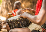 A closeup shot of two African men playing a musical instrument next to each other
