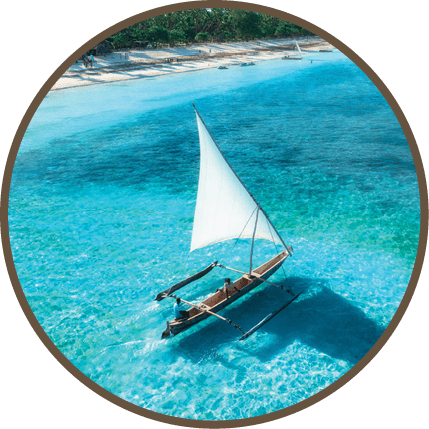 A white boat with a sail in the water. Description generated by AI
