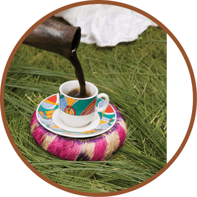 A colorful coffee cup with a saucer on a grassy field. Description generated by AI