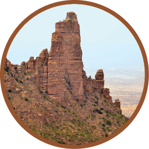 A mountain with a rock formation in the foreground. Description generated by AI