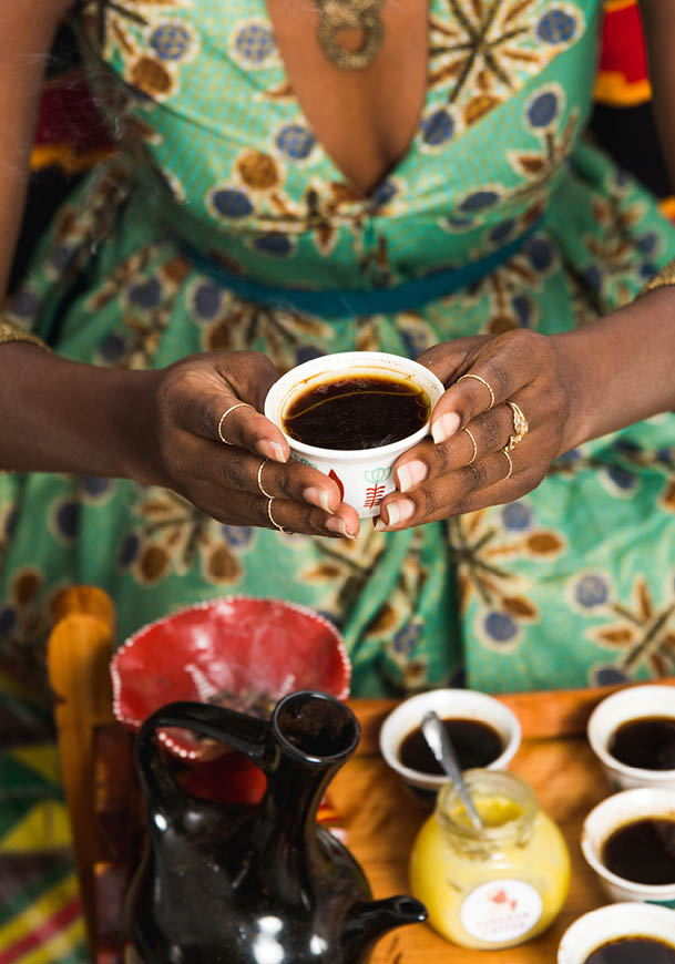 A woman holding a cup of coffee. Description generated by AI