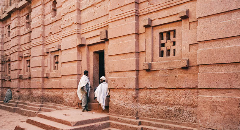 A man and woman are standing outside a building. Description generated by AI