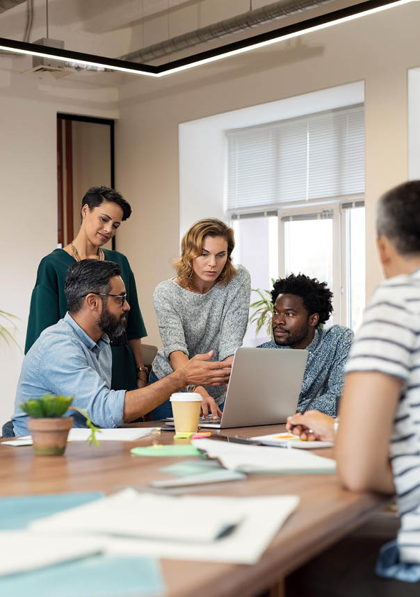 Busy multiethnic partners gathered to discuss some urgent matters. Group of creative businessmen and casual businesswomen discussing a new project in the office. Working together concept.