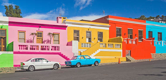 A colorful building with a car parked in front of it. AI generated content