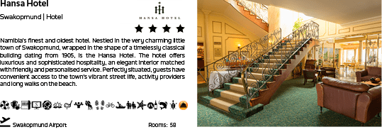 A hotel room with a couch and a chair. The room is decorated with a green carpet and a white wall. The room has a staircase leading to the upper floor. AI generated content