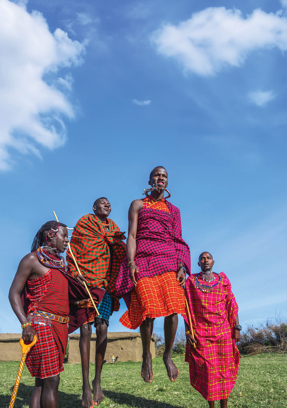 Maasai Mara man in traditional colorful clothing showing traditional Maasai jumping dance at Maasai Mara tribe village famous Safari travel destination near Maasai Mara National Reserve Kenya