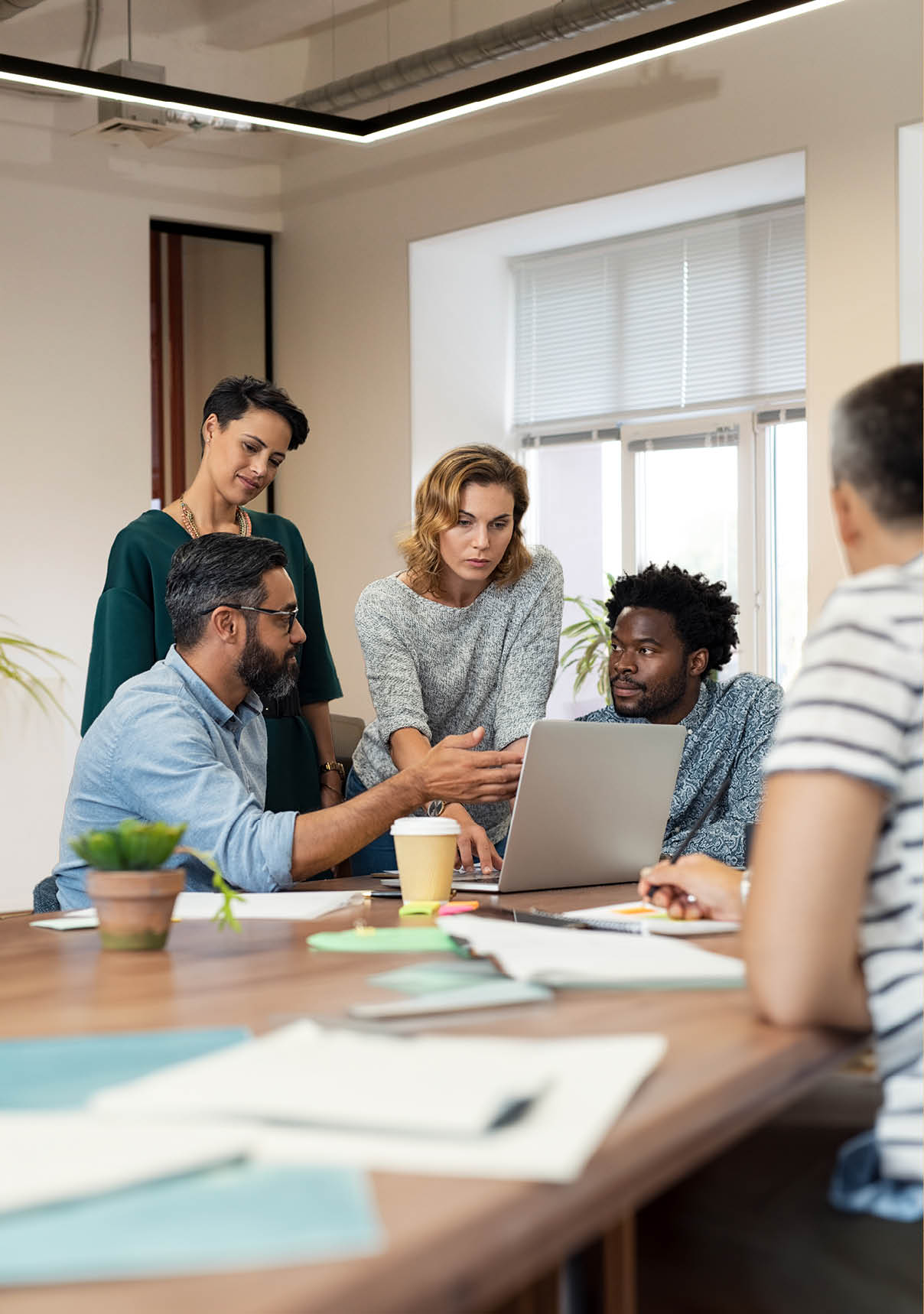 Busy multiethnic partners gathered to discuss some urgent matters. Group of creative businessmen and casual businesswomen discussing a new project in the office. Working together concept.