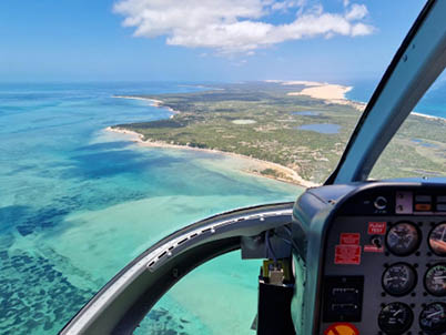 Helicopter flight from Ilha de Benguerra to Bazaruto Island off the coast of Mozambique, with views of the extensive beach and the sea