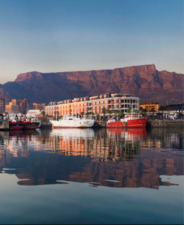 Early morning lighting on the waterfront and Table Mountain creates a perfect reflection in the harbour water infront of it. With fishing boads in the foreground and the City of Cape Town behind the waterfront