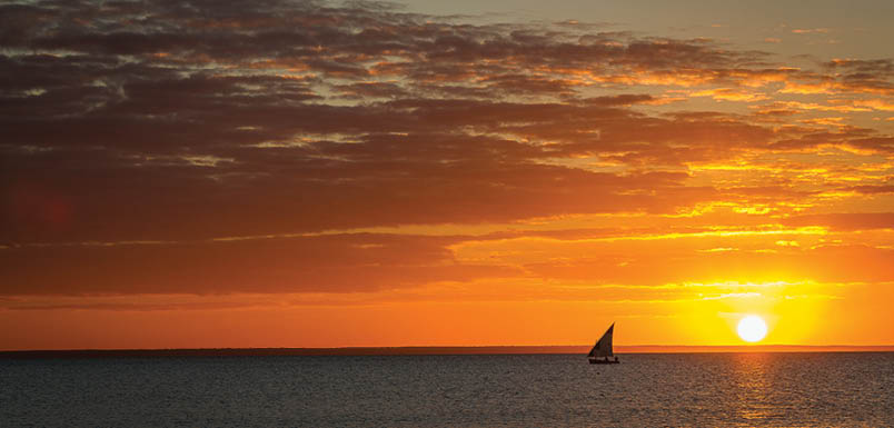 The sun is setting over the ocean. Description generated by AI