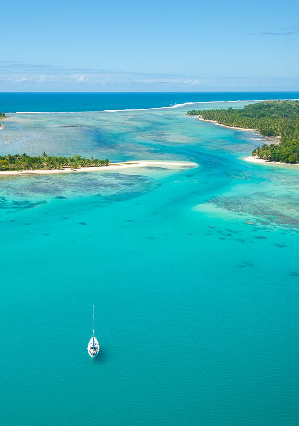 A boat is in the water near a sandy beach. Description generated by AI