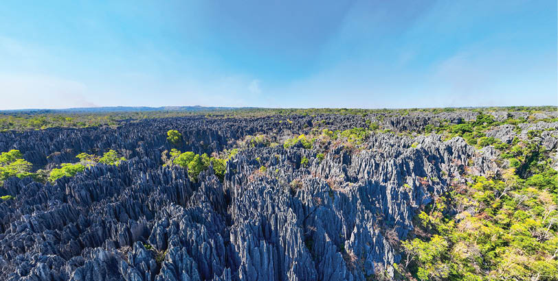 A large black rock formation with a blue sky above. Description generated by AI